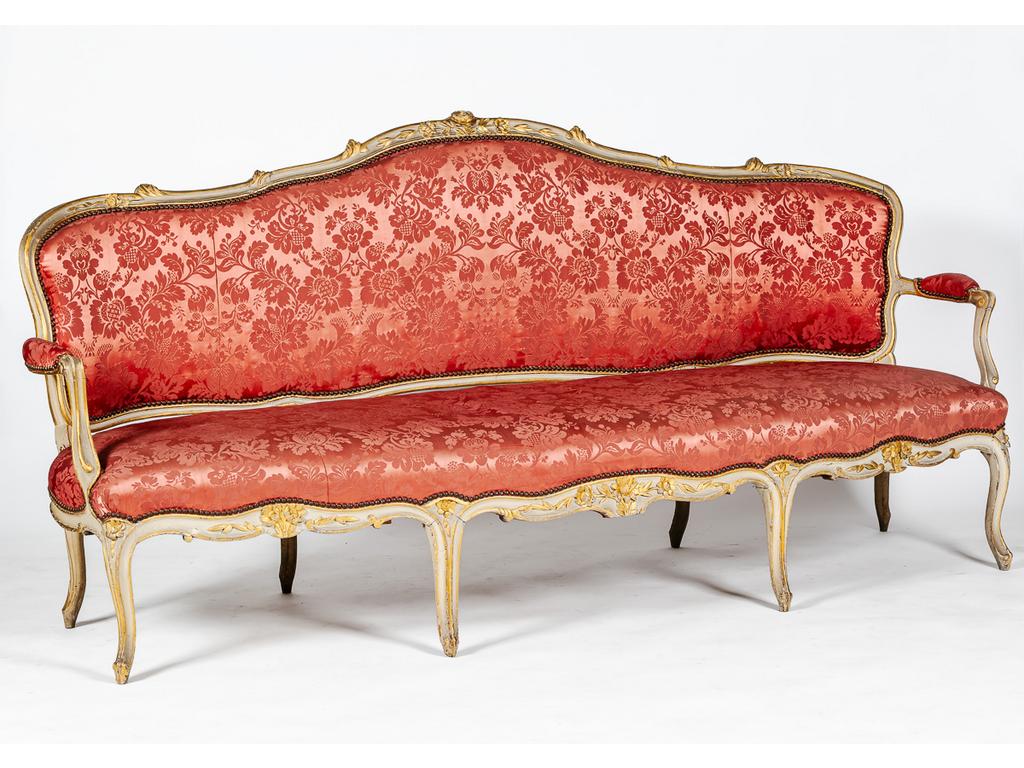 Important mobilier de salon d'époque Louis XV en bois laqué et doré à décor de fleurs et rinceaux sculptés comprenant : deux grands canapés reposant sur huit pieds cambrés et dix fauteuils cabriolet. (Etat d'usage, petits accidents et manques, réparations).