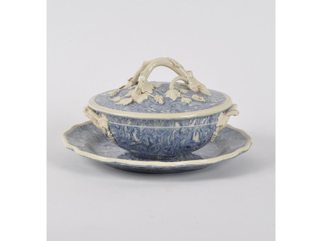 APT, Fabrique de FAUCON : Ecuelle et assiette présentoir en terre mêlée à fond bleu. prise de mains et anses en forme de sarments et pampres de vigne de couleur ivoire. Diamètre écuelle : 19 cm. Diamètre de l'assiette : 26 cm.