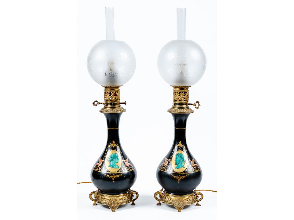 Paire de lampes à pétrole en métal laqué et laiton, à décor de profils à l'antique dans des médaillons entourés de chimères. Epoque XIXème siècle. (Montées à l'électricité). Hauteur totale : 70 cm.