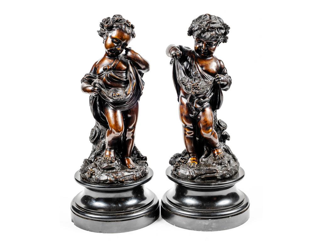 (D'après) CLODION : Paire de putti en bronze patiné reposant sur des socles en marbre noir (éclats). Hauteur totale : 55 cm.