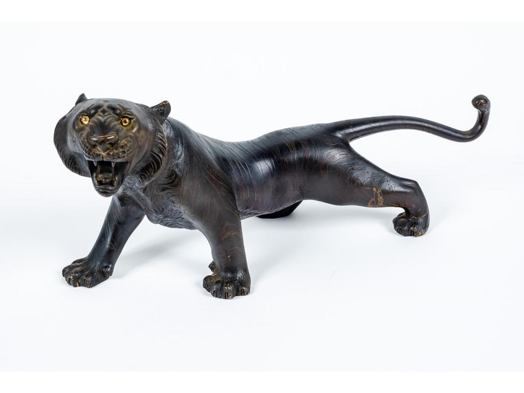 JAPON, Période Meiji : Tigre rugissant. Bronze à patine brune, les yeux en verre. Signé d'un cachet. Dim : 15 x 33 x 11 cm.