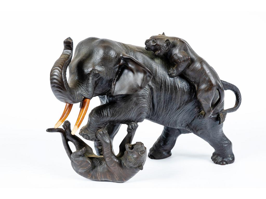 JAPON, Période Meiji : Eléphant attaqué par des tigres. Sujet en bronze patiné, signé d'un cachet. Dim : 18 x 28 x 14 cm.