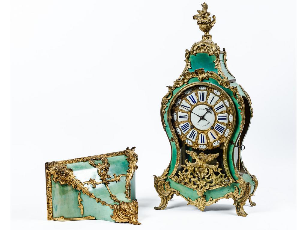 Cartel d'applique et son cul de lampe d'époque Louis XV en corne verte et bronze doré à riche décor rocaille, tête d'aigle et vase fleuri à l'amortissement. Cadran à cartouches émaillés de chiffres romains signé CHAL à Saint-Amand. Mouvement d'époque modifié au XIXème siècle. Dim : 77 x 36 x 15 cm. Dim cul de lampe : 31 x 40 x 21 cm.