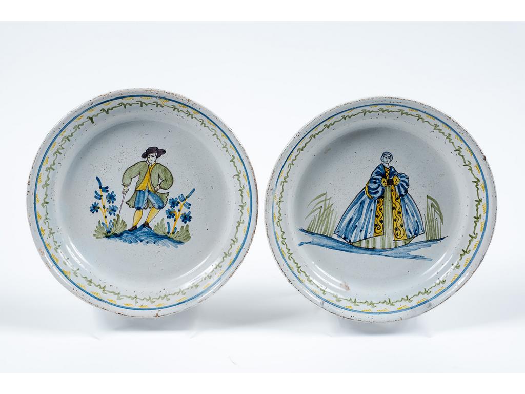 CENTRE : Paire d'assiettes en faïence polychrome de grand feu représentant un homme à l'épée et une femme en robe longue. Fin XVIIIème siècle. Diamètre : 22 cm