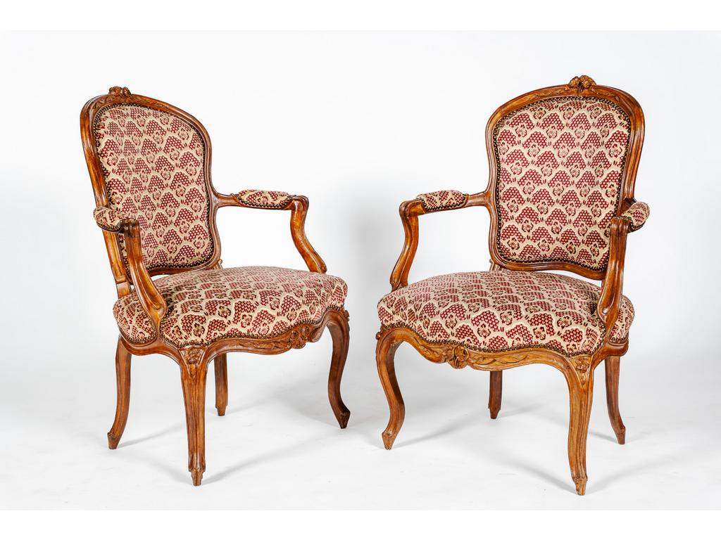 Paire de fauteuils cabriolets d'époque Louis XV en noyer naturel mouluré et sculpté de roses et feuillages.