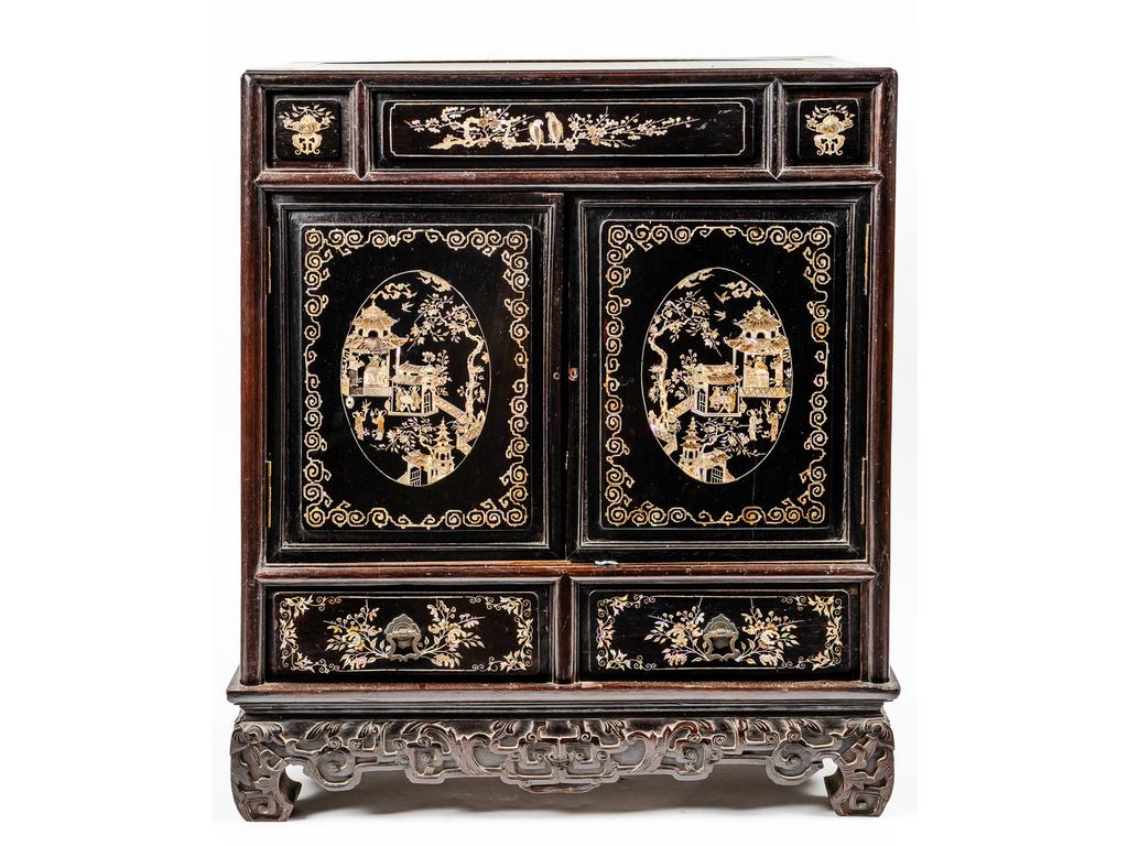 EXTREME ORIENT : Petit cabinet en bois exotique à décor de paysages animés de personnages et de pagodes en nacre incrustée. Il ouvre par un tiroir et deux vantaux en façade et repose sur un piétement relié par une traverse sculptée de motifs stylisés. Fin XIXème siècle. Dimensions : 63 x 56 x 35 cm
