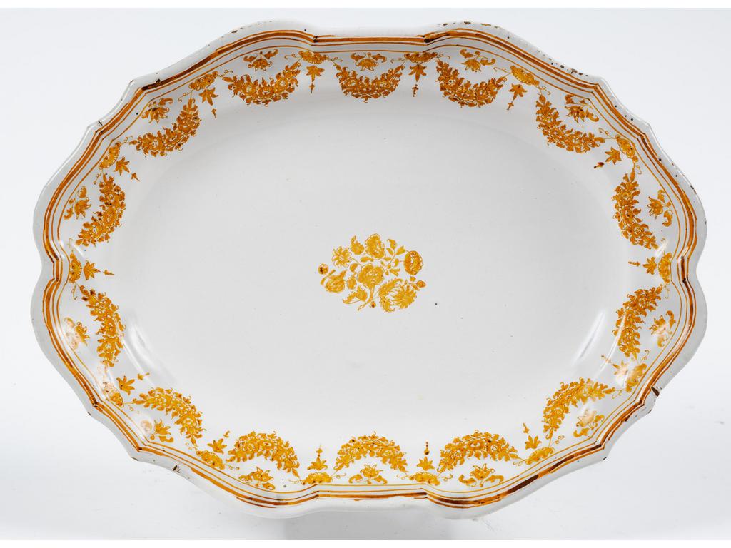 MOUSTIERS, XVIIIème siècle : Plat oblong à décor floral en camaïeu jaune. Signé du monogramme 