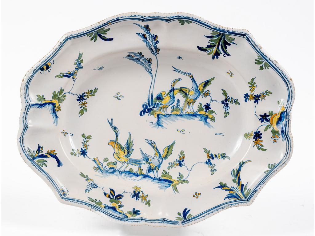 MOUSTIERS, XVIIIème siècle : Plat oblong à décor polychrome d'oiseaux sur des tertres dans un entourage de feuillages. Dim : 29 x 37 cm.