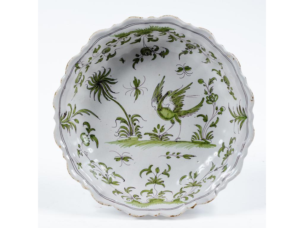 MOUSTIERS : Plat rond et creux en faïence à décor camaïeu vert d'un échassier et branchages. Epoque XVIIIème siècle. Diamètre : 29 cm.