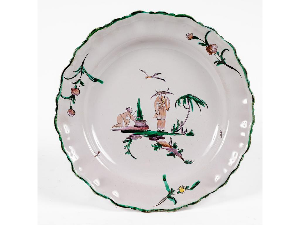 MOUSTIERS, Thion, XVIIIème siècle. Assiette en faïence de petit feu à décor polychrome de chinois à la Pillement. Diamètre : 24.5 cm.