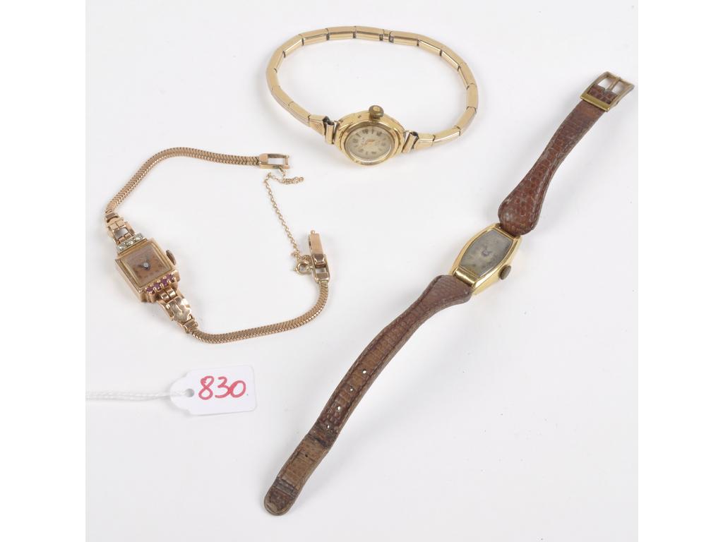 Lot de 3 montres de dame 2 en 18K et 1 en 14k. Rayures et déformations: Les 2 montres avec boîtiers en or jaune bracelets cuir et métal. Poinçons têtes daigle. PB: 24. La montre bracelet Art Déco Régnal en or jaune 14k (AC) avec 3 petits diamants et pierres rouges. PB: 17.7g