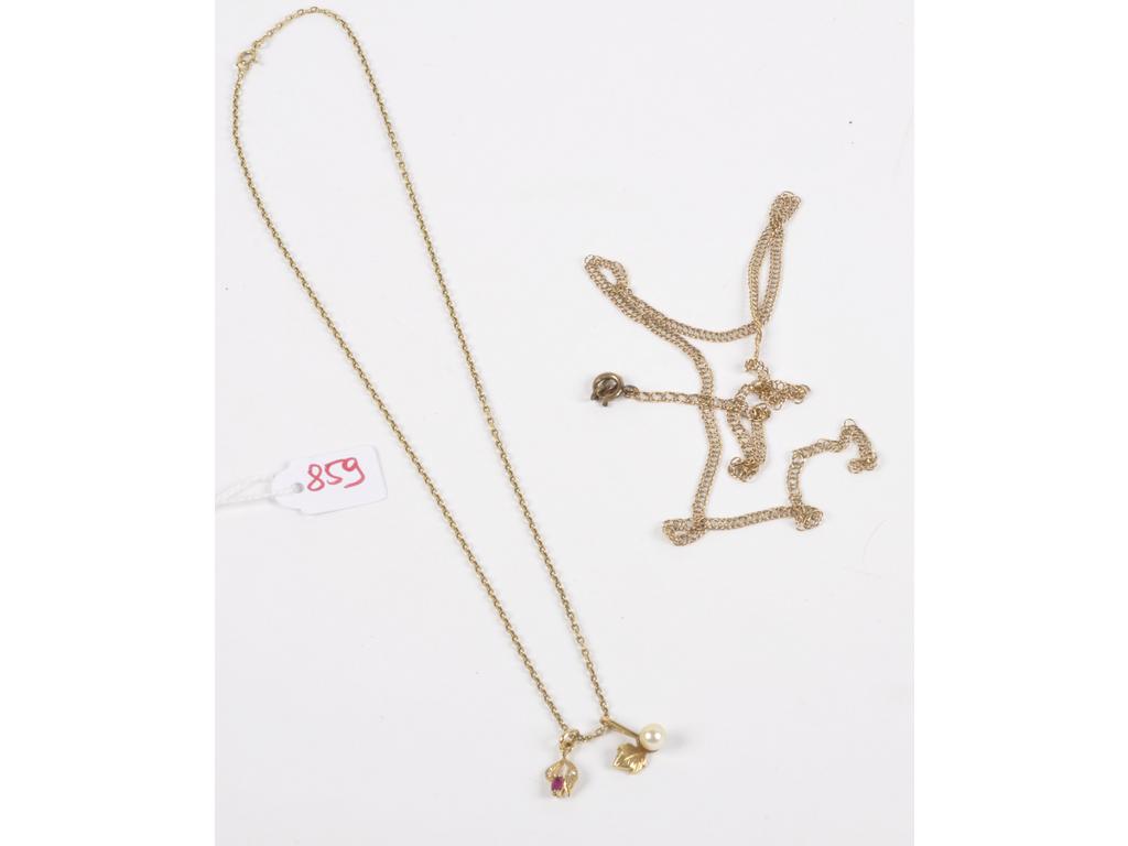 Deux chaînes dont une accidentée et deux pendentifs en or jaune. Un pendentif avec perle de culture blanches et lautre avec rubis. Poinçons têtes daigles. Un anneau ressort en métal. (1AC). PB total : 10.4g