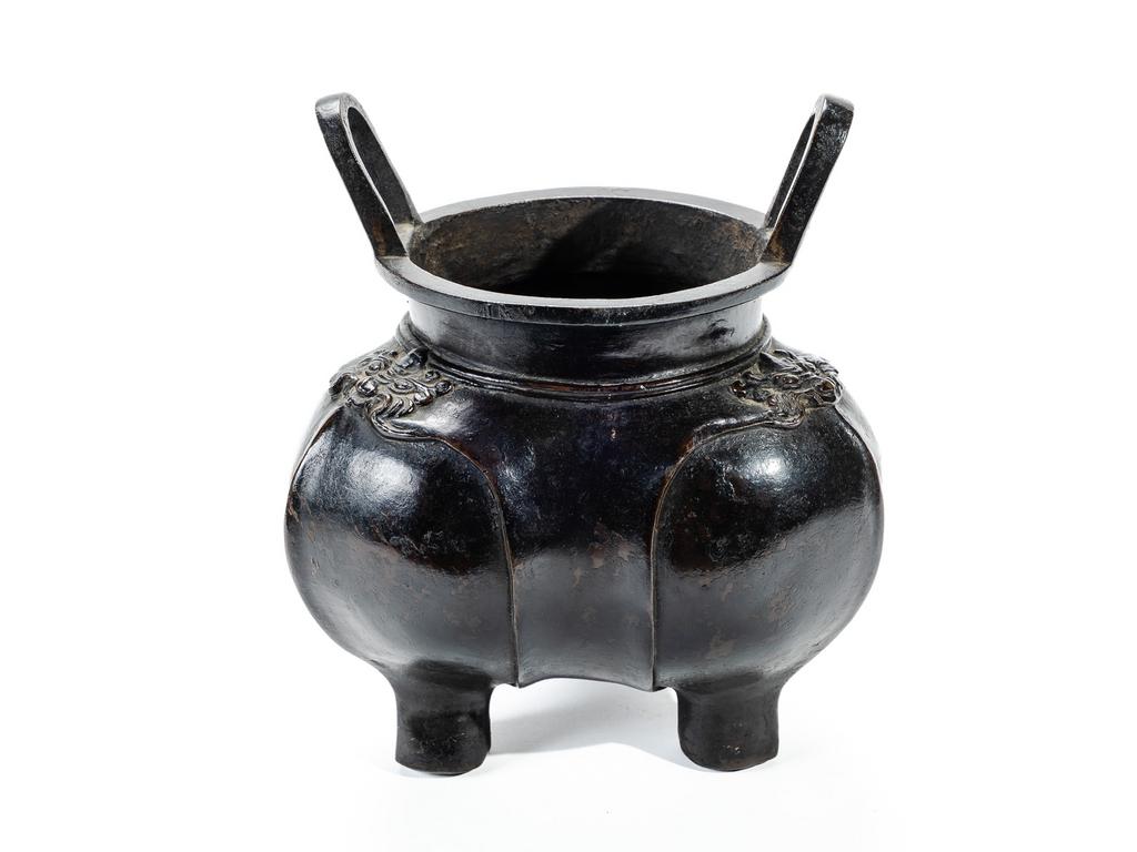 CHINE : Brûle-parfum tripode à anses en bronze patiné à décor de têtes de dragons. (manque le couvercle). Haut. : 21.5 cm