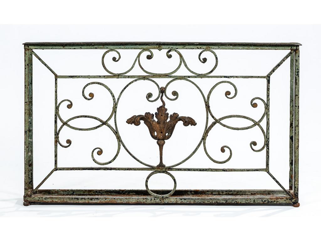 Ancien garde-corps en fer forgé à décor d'acanthes et volutes, transformé en porte-parapluies. (Traces de rouille). Dim : 62 x 102 x 14 cm.