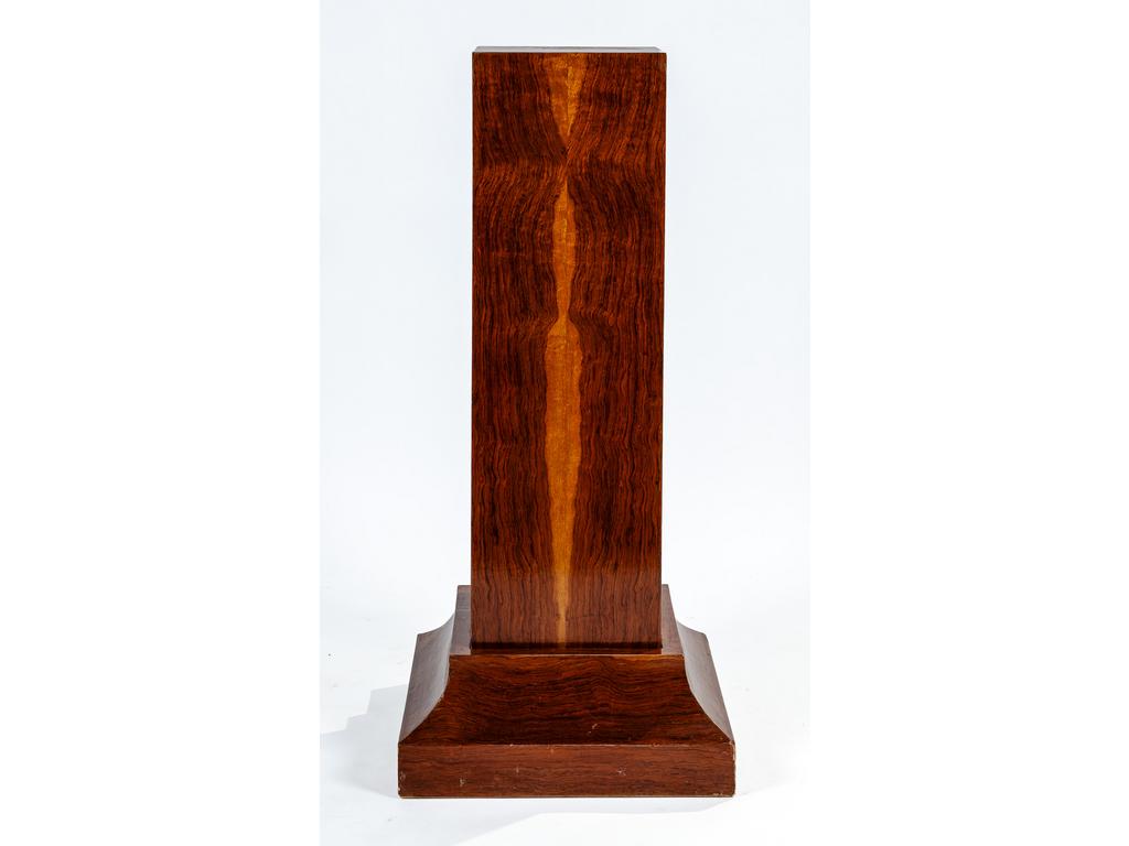 Important socle en forme de pilastre en placage de bois exotique reposant sur une plinthe moulurée. Début du XXème siècle. Hauteur : 113.5 cm.