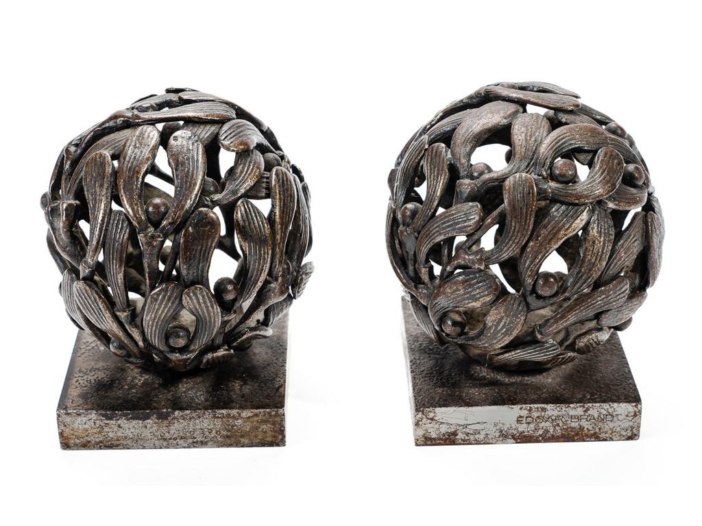 Edgard BRANDT (1880-1960) : Paire de petites boules de gui en bronze patiné reposant sur des socles carrés en acier. (Traces de rouilles). Une seule boule signée. Hauteur totale : 10 cm.