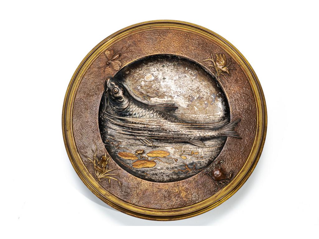 Plat en bronze et cuivre à décor Japonisant, en bas-relief, figurent une carpe dans un entourage d'insectes, batraciens et crustacés. Travail Français vers 1900. Diamètre : 33.5 cm.