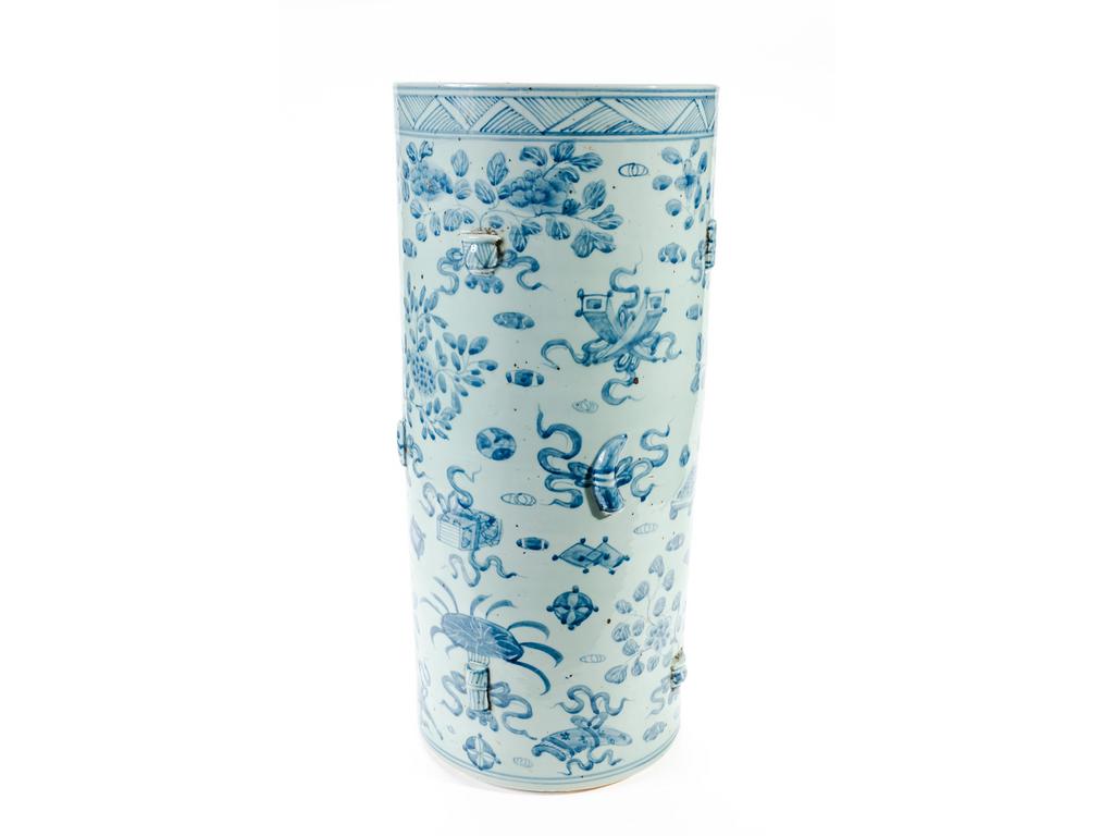CHINE : Grand porte-parapluie en porcelaine à décor bleu et blanc de vases fleuris et petits ameublements. Vers 1900. (Petits fêles de cuisson). Hauteur : 60 cm. Diamètre : 27.5 cm.