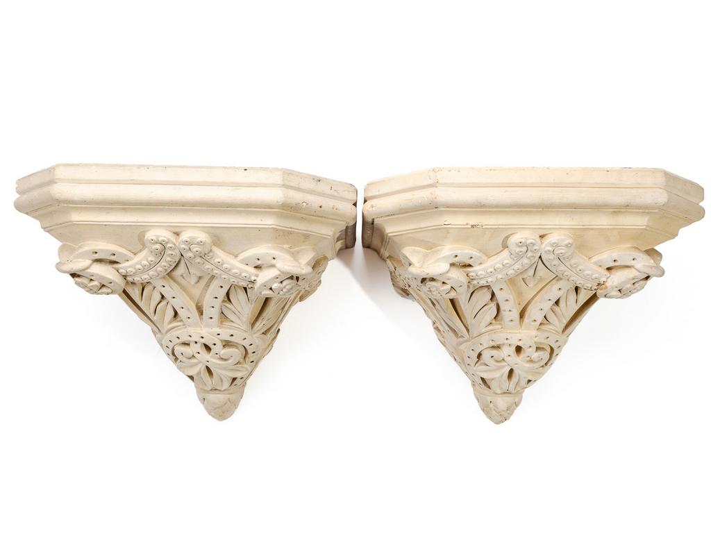 Paire de consoles d'applique en plâtre moulé et patiné à décor d'entrelacs et feuillage. Dim : 30 x 37.5 x 31.5 cm.