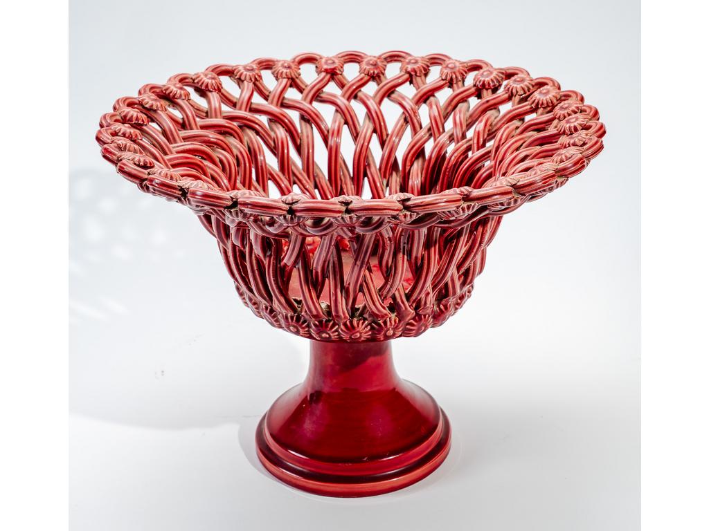 Manufacture PICHON à Uzès : Grande corbeille sur piédouche en faïence tressée émaillée rouge à décor de fleurettes stylisées. Signée du cachet de Jean-Paul PICHON. Hauteur : 27 cm. Diamètre : 35 cm.