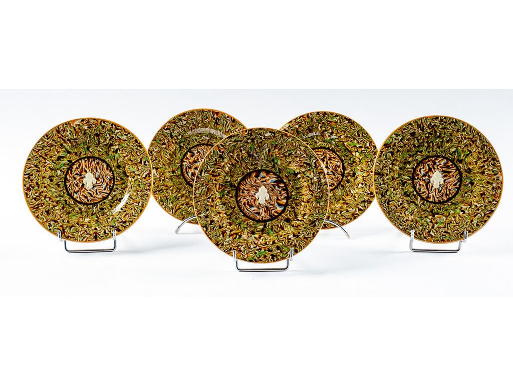 Manufacture PICHON à Uzès : Suite de cinq assiettes en céramique à décor de rosaces centrées de fleurs de lys en relief sur fond marbré en terres mêlées. Une signée du cachet de François PICHON. (Une avec petit éclat au talon). Diamètre : 21 cm.