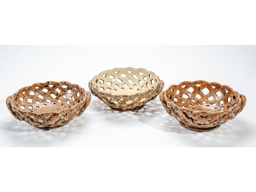 Manufacture PICHON à Uzès : Trois corbeilles à anses en céramique tressée et ajourée à décor marbré en terres mêlées. (Une avec important fêle de cuisson sous la base). Hauteurs : 8,5 cm. Diamètres : 24 cm.