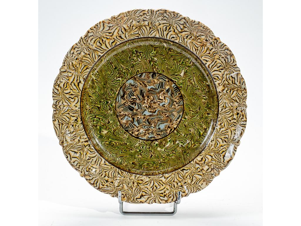 Manufacture PICHON à Uzès : Plat à aile chantournée en céramique à décor de rosace sur fond marbré en terres mêlées. Diamètre : 28,5 cm.