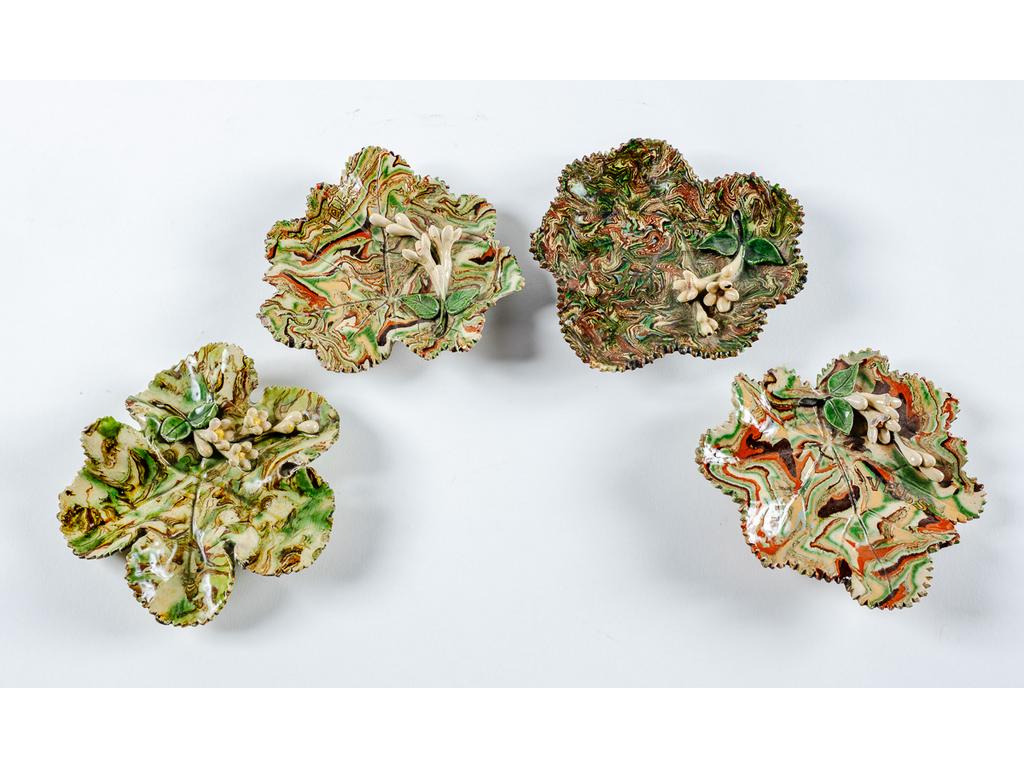 Manufacture PICHON à Uzès : Quatre coupes vide-poche en forme de feuilles à décor, en relief, de fleurs sur fond marbré en terres mêlées. (Petits éclats). Dimensions : de 3,5 x 12,5 x 13 cm à 2,5 x 14,5 x 14 cm.