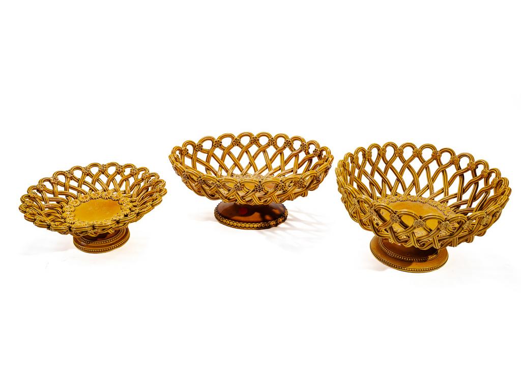 Manufacture PICHON à Uzès : Trois corbeilles sur piédouche en faïence émaillée, tressée et ajourée à décor de fleurettes et rais de perles. Signées du cachet. Hauteurs : de 9,5 cm à 14 cm.