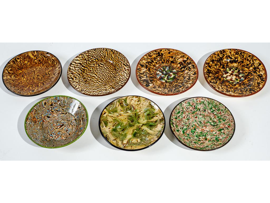 Manufacture PICHON à Uzès : Sept soucoupes dépareillées à décor marbré en terres mêlées. Signées au cachet. Diamètres : de 13 cm à 14,5 cm.