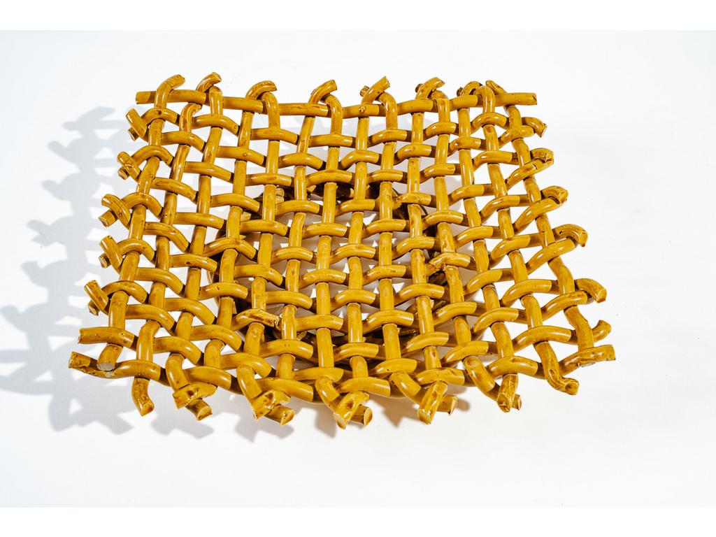 Manufacture PICHON à Uzès : Une corbeille en faïence tressée, émaillée et ajourée à l'imitation de la vannerie. Dimensions : 7 x 33,5 x 35 cm.