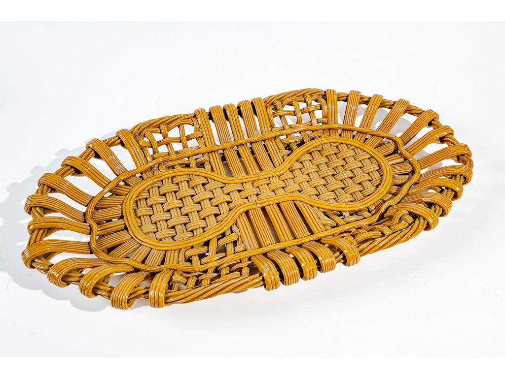 Manufacture PICHON à Uzès : Une grande corbeille ovale en faïence tressée, émaillée et ajourée à l'imitation de la vannerie. (Fêles de cuisson). Dimensions : 6,5 x 65,5 x 35 cm.