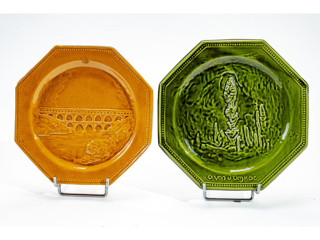 Manufacture PICHON à Uzès : Deux assiettes octogonales en faïence émaillée représentant, en léger relief, lAven dOrgnac et le Pont du Gard. Signées du cachet de Bernard PICHON. Diamètres : 23 cm et 24,5 cm.