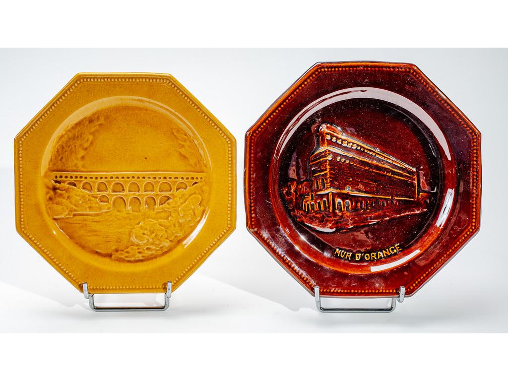 Manufacture PICHON à Uzès : Deux assiettes octogonales en faïence émaillée représentant, en léger relief, le mur dOrange et le Pont du Gard. Signées du cachet de Bernard PICHON. Diamètres : 23 cm et 24,5 cm.
