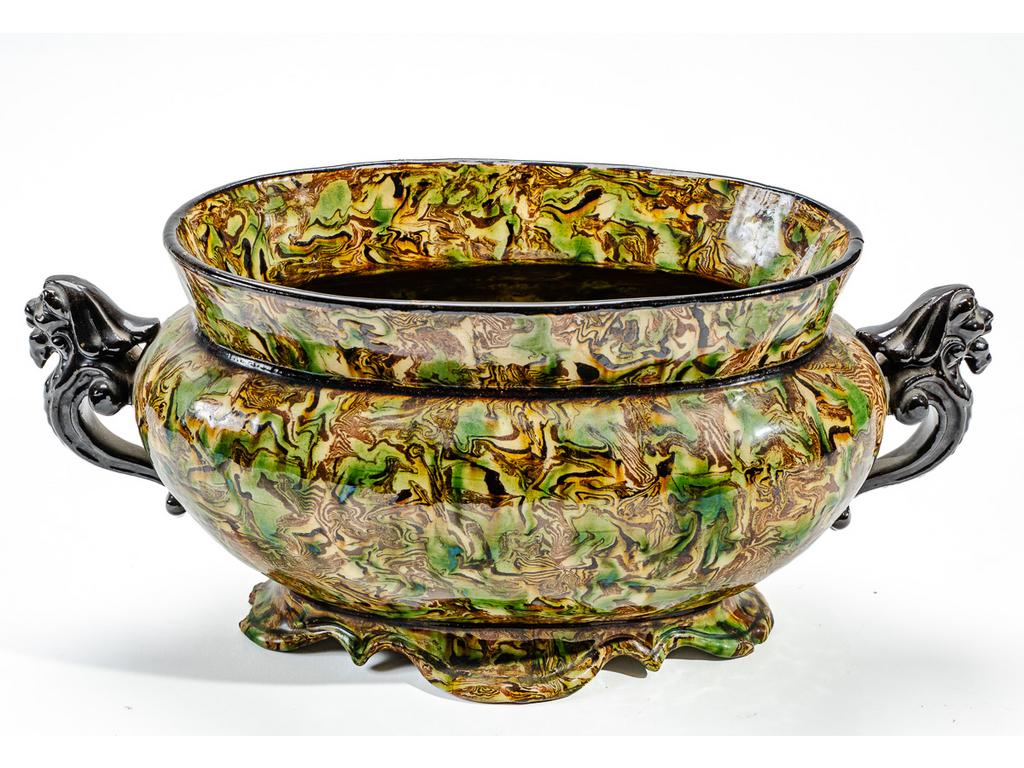 Manufacture PICHON à Uzès : Jardinière de table marbrée en terres mêlées, ornée de deux anses à tête de lion. Signée du cachet. Dimensions : 17 x 37 x 16 cm.