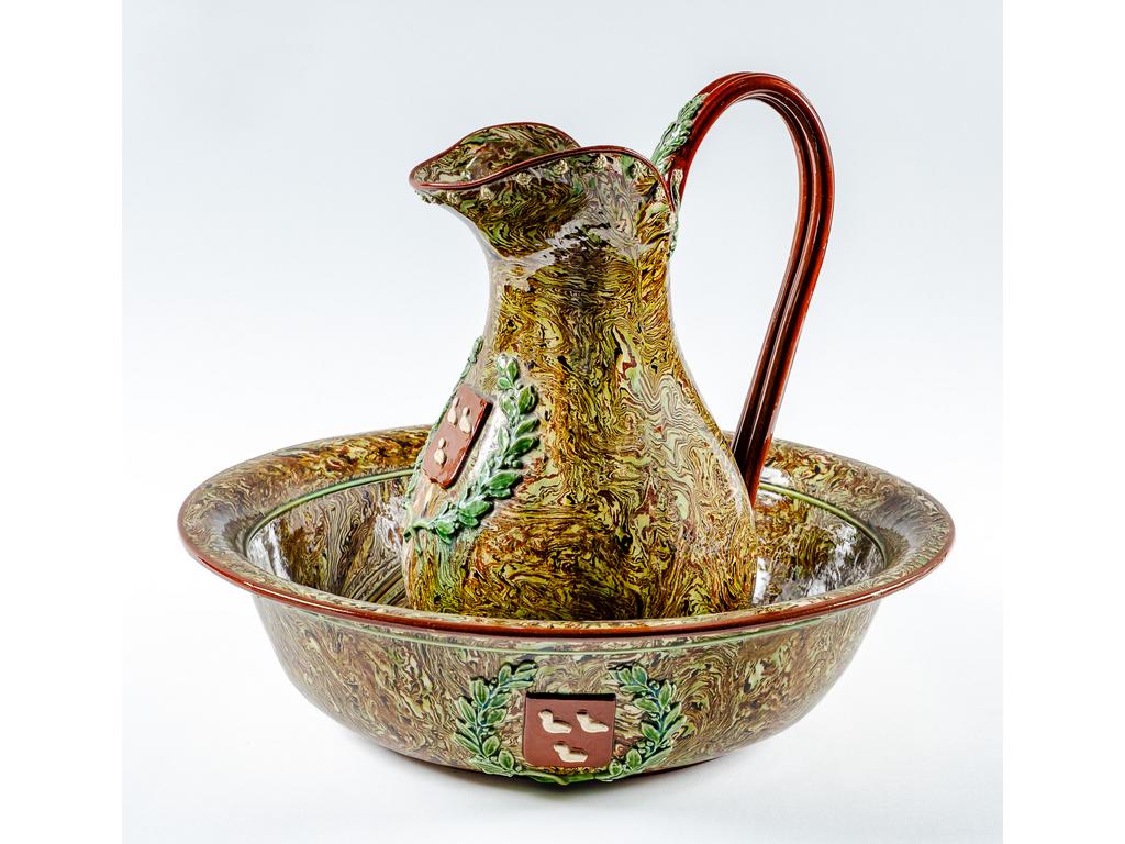 Manufacture PICHON à Uzès : Broc et son bassin en céramique ornés d'un blason dans une couronne de lauriers sur fond marbré en terres mêlées. Signés du cachet de François PICHON. Hauteur du broc : 30 cm. Diamètre du bassin : 41 cm.