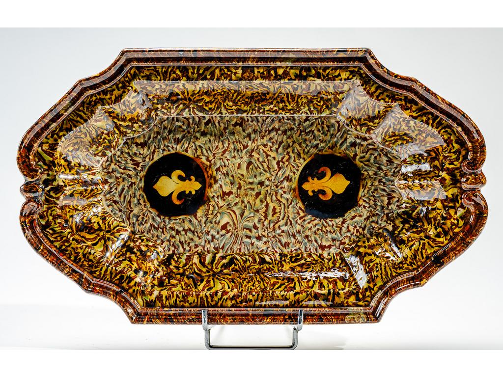 Manufacture PICHON à Uzès : Plat ovale en céramique à aile chantournée et à décor de fleurs de lys sur fond marbré en terres mêlées. Signé du cachet de François PICHON. (Fêles de cuisson). Dimensions : 43 x 25,5 cm.
