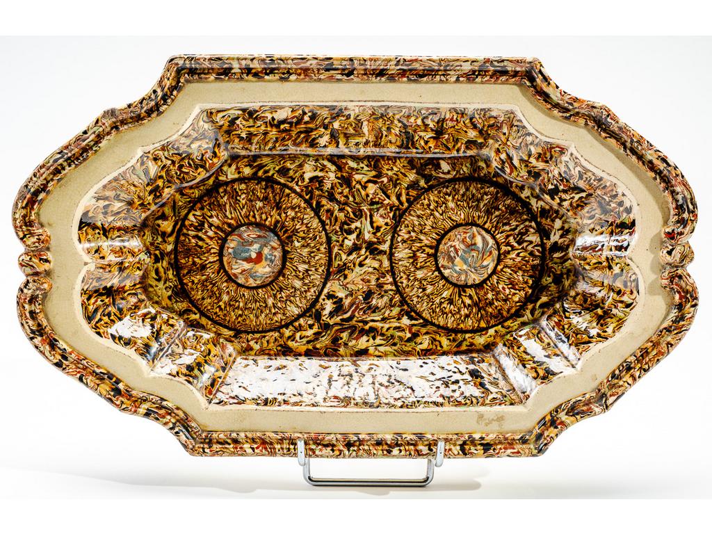 Manufacture PICHON à Uzès : Plat ovale en céramique à aile chantournée et à décor de rosaces sur fond marbré en terres mêlées. Signé du cachet de François PICHON. Dimensions : 43 x 25,5 cm.