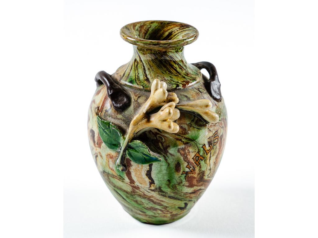 Manufacture PICHON à Uzès : Petit vase à anses de forme balustre à décor, en relief, de fleurs sur fond marbré en terres mêlées et orné de l'inscription « VALS » en lettres dorées. Hauteur : 11 cm.