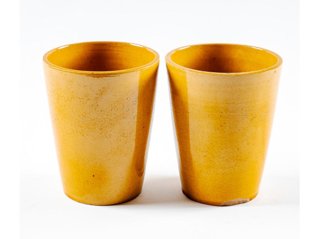 Manufacture PICHON à Uzès : Paire de petits cache-pots en faïence émaillée ocre. Signée du cachet de Bernard PICHON. (Un avec éclats et fêle). Hauteurs : 12,5 cm. Diamètre : 10 cm.