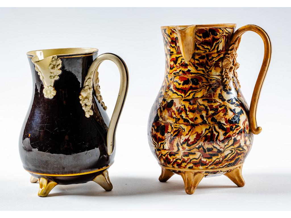 Manufacture PICHON à Uzès : Deux petites verseuses en céramique sur pied. Une à décor marbré en terres mêlées, l'autre à décor de fleurs ivoire sur fond brun. Signées du cachet « F. PICHON à Uzès médaillé 1863 » dans un cartouche. Hauteurs : 17 cm et 14 cm.