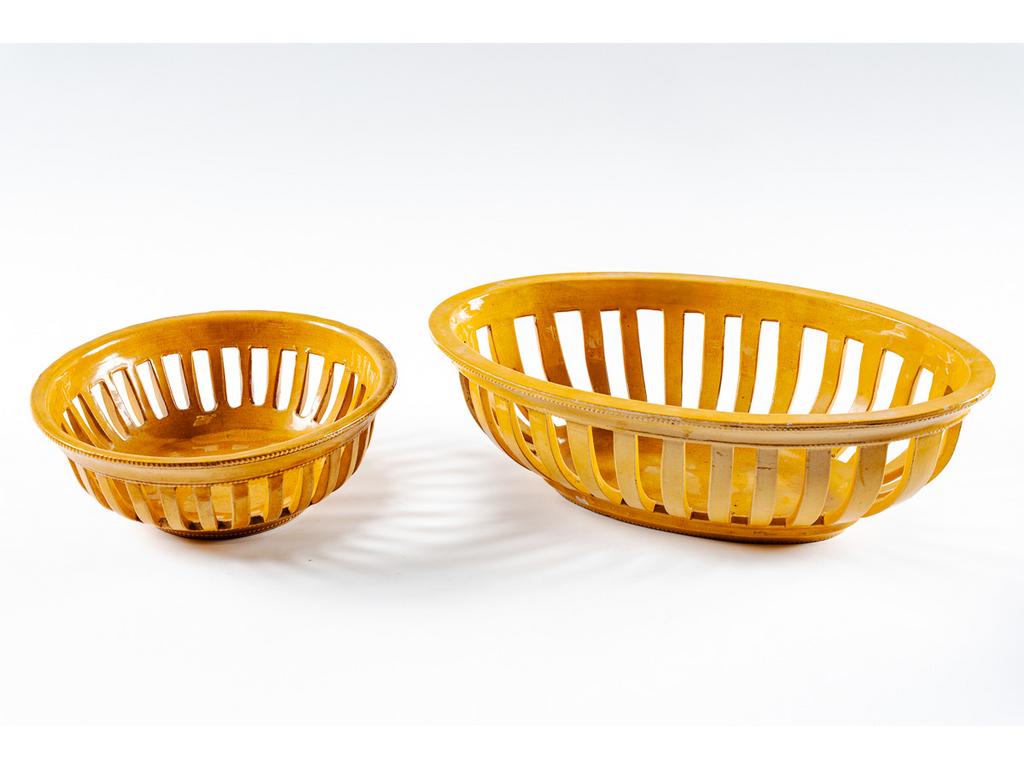 Manufacture PICHON à Uzès : Une corbeille oblongue et une corbeille ronde en faïence ajourée à décor de rais de perles. Signées du cachet de Bernard PICHON. (Petits éclats et fêles de cuisson). Dimensions de la première : 12 x 38,5 x 24,5 cm. Dimensions de la seconde : Hauteur : 9,5 cm, Diamètre : 25 cm.