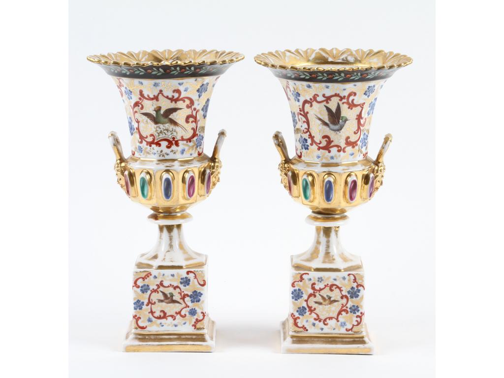 PARIS : Paire de vases type Médicis en porcelaine blanche richement peints et dorés, ornés de cabochons de couleur. Hauteur : 29 cm. (Bon état général, usures importantes à la dorure)