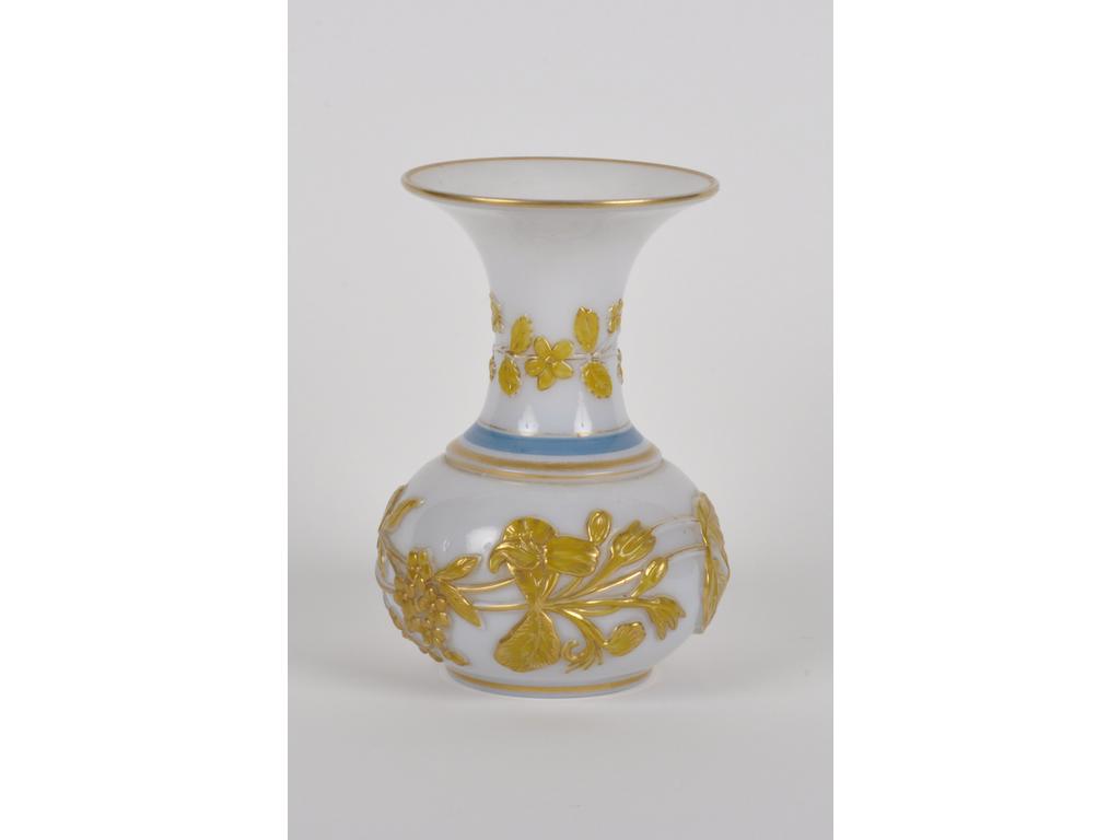 Vase en opaline moulée blanche orné d'un liseré bleu et d'un décor de feuillages en relief mordoré. Hauteur : 20 cm. (Bon état).