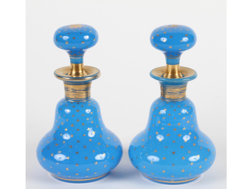 Paire de petits flacons en opaline bleue à décor d'un semis de petites étoiles dorées. Bon état général. Quelques usures à la dorure. Hauteur : 14 cm.