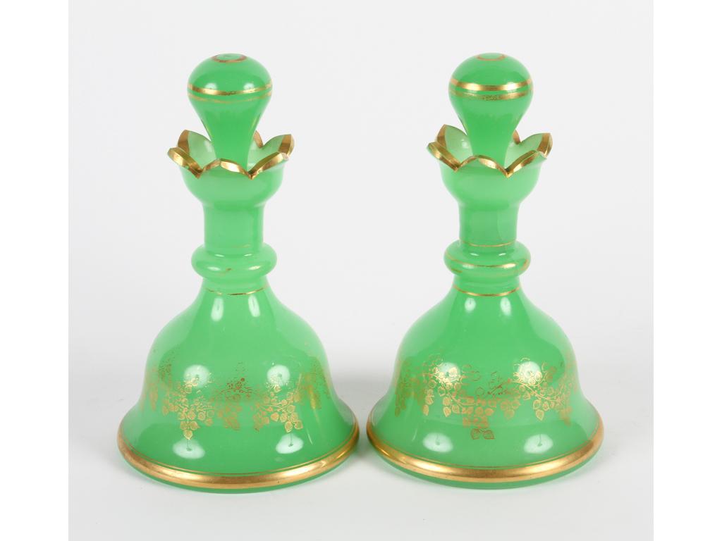 Paire de flacons en opaline verte à décor de liserés et branchages dorés. (Bon état général, quelques usures à la dorure, un bouchon coincé). Hauteur : 19 m.