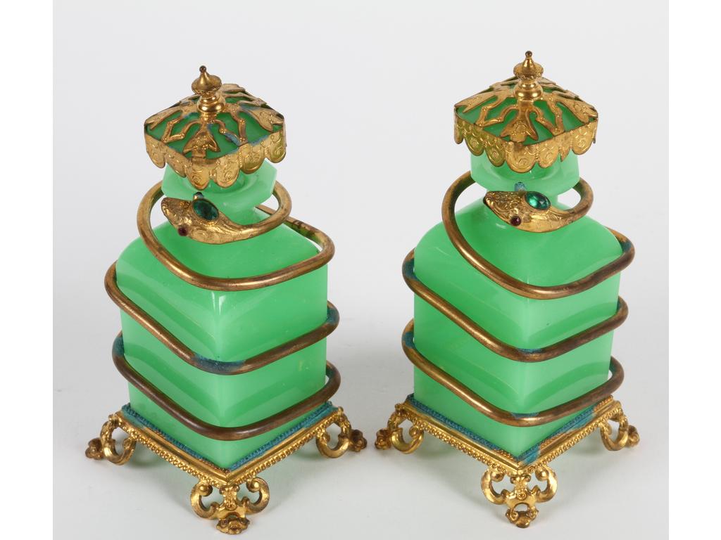 Paire de flacons en opaline verte ornés d'une monture en laiton et tôle dorée à décor d'un serpent (Infimes éclats sur le col, traces de vert de gris sur la monture). Hauteur : 15 cm.