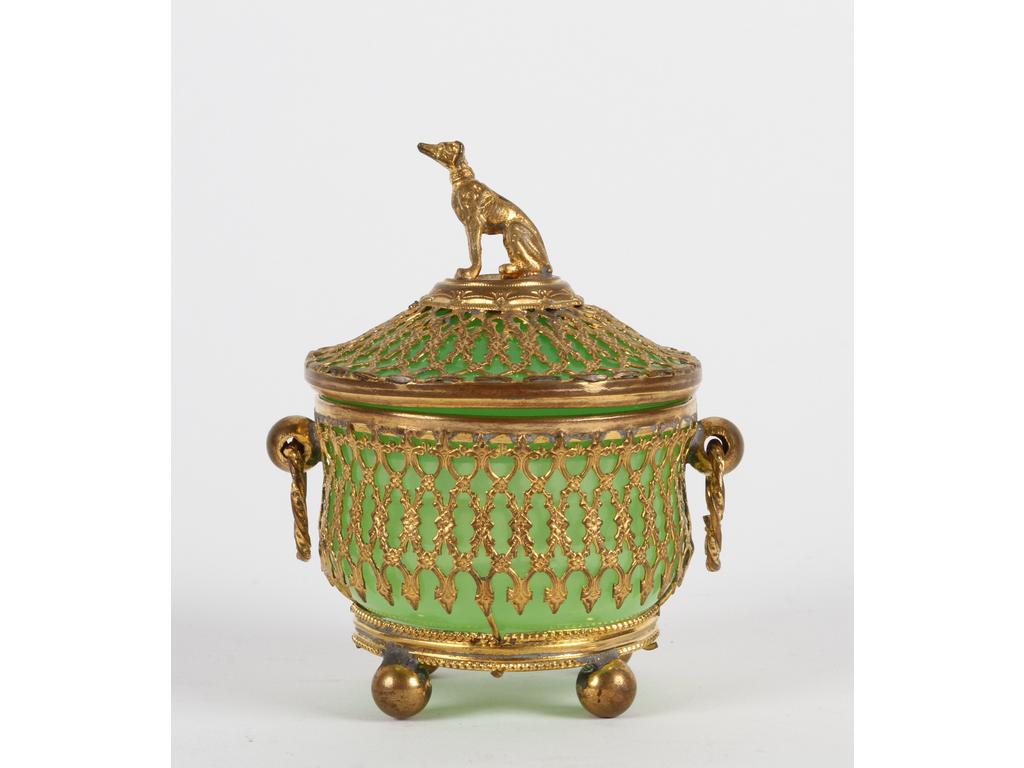 Petite boîte ronde on opaline verte sur une monture en laiton et tôle dorée avec deux anses. Le fretel en forme de chien assis. Bon état, quelques oxydations. Hauteur : 11 cm.