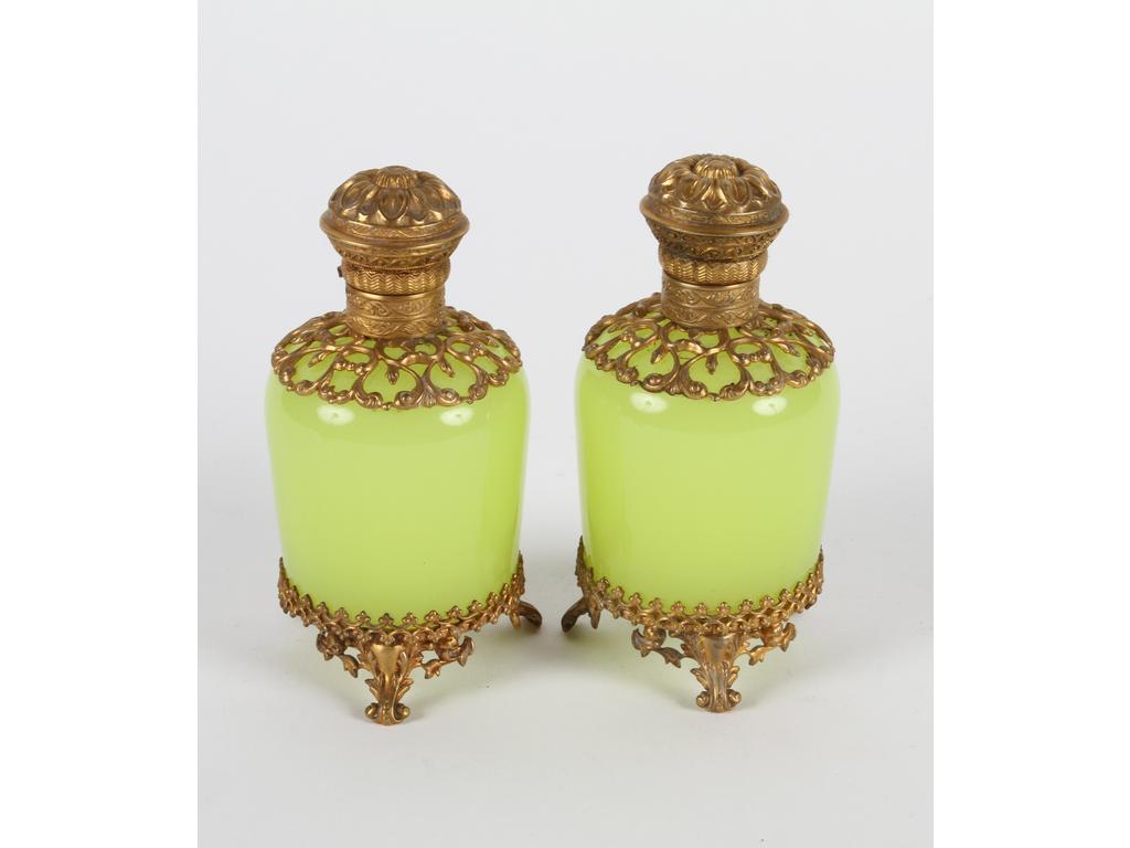 Paire de petits flacons en opaline jaune, ornés d'une monture et de bouchons en laiton et tôle dorée. Bon état. Hauteur : 11 cm.