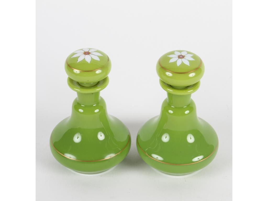 Paire de petits flacons piriformes en opaline vert olive. Les bouchons à décor d'une fleur en verre blanc et coeur en millefiori. Hauteur : 12. (Bon état, infimes usures sur liseré doré)